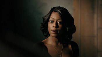Movie still from “Snowfall” (2017), directed by Hiro Murai – A black woman with short black hair wearing a black top; Close Up shot, Over the shoulder angle