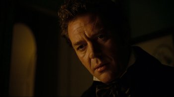 Movie still from “Alice in Wonderland” (2010), directed by Tim Burton – A person wearing a suit and bow tie; Close Up shot, Over the shoulder angle