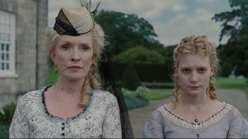 Movie still from “Alice in Wonderland” (2010), directed by Tim Burton – Two women dressed in period clothing standing next to each other; Close Up shot, Low angle