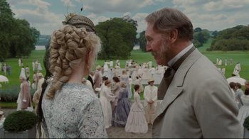 Movie still from “Alice in Wonderland” (2010), directed by Tim Burton – A man and a woman standing next to each other in front of a group of people; Medium shot, Over the shoulder angle