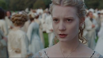 Movie still from “Alice in Wonderland” (2010), directed by Tim Burton – A young woman in front of a group of people; Close Up shot, Over the shoulder angle