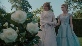 Movie still from “Alice in Wonderland” (2010), directed by Tim Burton – Two women dressed in period clothing standing next to each other in front of a rose bush; Medium shot, Low angle