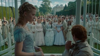 Movie still from “Alice in Wonderland” (2010), directed by Tim Burton – A group of people in formal wear standing in a field; Wide shot, Over the shoulder angle