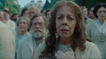 Movie still from “Alice in Wonderland” (2010), directed by Tim Burton – An old woman standing in front of a group of people; Close Up shot, Over the shoulder angle