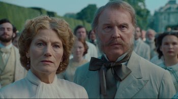 Movie still from “Alice in Wonderland” (2010), directed by Tim Burton – A man and a woman standing next to each other in front of a crowd; Close Up shot, Low angle