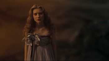 Movie still from “Alice in Wonderland” (2010), directed by Tim Burton – A woman with long blonde curly hair wearing a dress; Close Up shot, Low angle