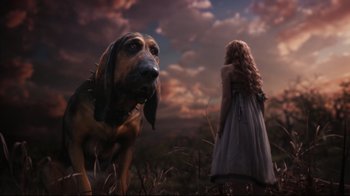 Movie still from “Alice in Wonderland” (2010), directed by Tim Burton – A woman and a dog in a grassy field; Wide shot, Low angle