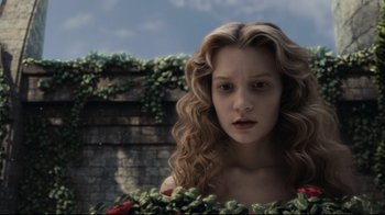 Movie still from “Alice in Wonderland” (2010), directed by Tim Burton – A woman with long blonde curly hair wearing a red dress; Close Up shot, High angle