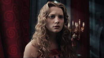Movie still from “Alice in Wonderland” (2010), directed by Tim Burton – A woman with long blonde curly hair wearing a red dress; Close Up shot, Low angle