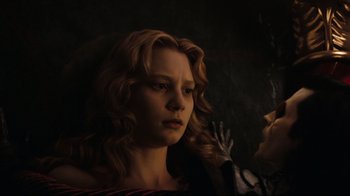 Movie still from “Alice in Wonderland” (2010), directed by Tim Burton – A woman with long blonde curly hair looking at the camera; Close Up shot, Low angle