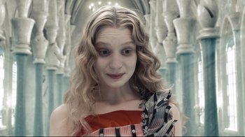 Movie still from “Alice in Wonderland” (2010), directed by Tim Burton – A woman with long blonde curly hair wearing a red and black dress; Close Up shot, High angle