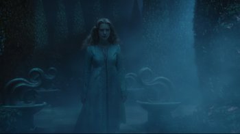 Movie still from “Alice in Wonderland” (2010), directed by Tim Burton – A woman standing in a room with a fountain in front of her; Wide shot, Over the shoulder angle