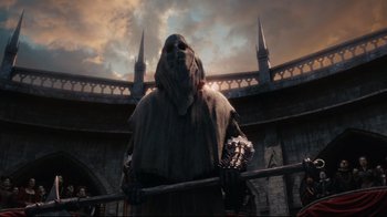 Movie still from “Alice in Wonderland” (2010), directed by Tim Burton – A man in a costume standing in front of a building; Wide shot, Low angle