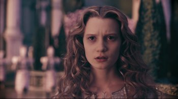 Movie still from “Alice in Wonderland” (2010), directed by Tim Burton – A young woman with long , curly hair stares into the camera; Close Up shot, High angle