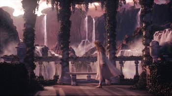Movie still from “Alice in Wonderland” (2010), directed by Tim Burton – A woman standing in front of a waterfall and a bench; Wide shot, High angle