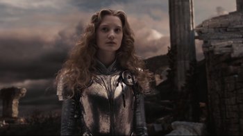 Movie still from “Alice in Wonderland” (2010), directed by Tim Burton – A woman with long curly hair wearing a metal suit; Medium shot, Low angle