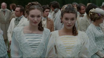 Movie still from “Alice in Wonderland” (2010), directed by Tim Burton – Two women in white dresses standing next to each other in a crowd; Medium shot, Low angle