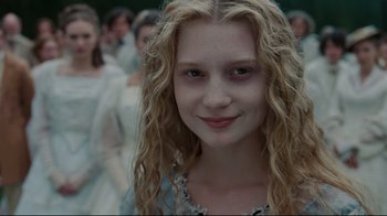 Movie still from “Alice in Wonderland” (2010), directed by Tim Burton – A young woman with long blonde hair and a blue dress; Close Up shot, Over the shoulder angle