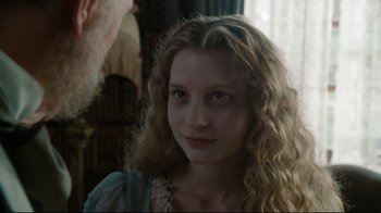 Movie still from “Alice in Wonderland” (2010), directed by Tim Burton – A woman with long blonde curly hair wearing a blue dress; Close Up shot, Over the shoulder angle