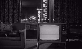 Movie still from “Alice in the Cities” (1974), directed by Wim Wenders – A black and white photo of a television set in a room; Wide shot, High angle