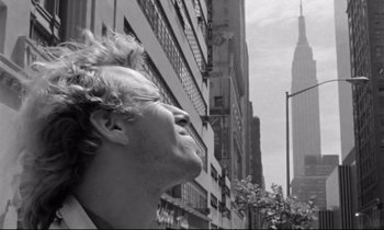 Movie still from “Alice in the Cities” (1974), directed by Wim Wenders – A black and white photo of a man looking up at the sky; Close Up shot, Low angle