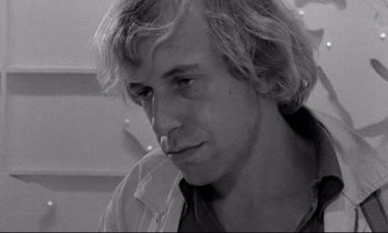 Movie still from “Alice in the Cities” (1974), directed by Wim Wenders – Black and white photograph of a man with long blonde hair; Close Up shot, Over the shoulder angle