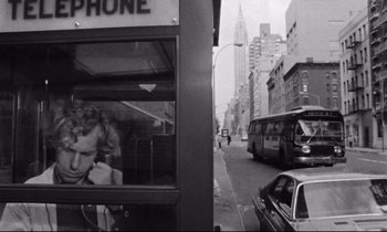 Movie still from “Alice in the Cities” (1974), directed by Wim Wenders – A bus is driving down the street past a phone booth; Medium shot, Low angle