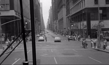 Movie still from “Alice in the Cities” (1974), directed by Wim Wenders – A black and white photo of a city street; Extreme Wide shot, High angle