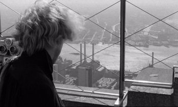 Movie still from “Alice in the Cities” (1974), directed by Wim Wenders – A man standing on top of a building looking out over a city; Close Up shot, Over the shoulder angle