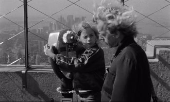 Movie still from “Alice in the Cities” (1974), directed by Wim Wenders – A woman and a girl looking through a telescope; Medium shot, Low angle