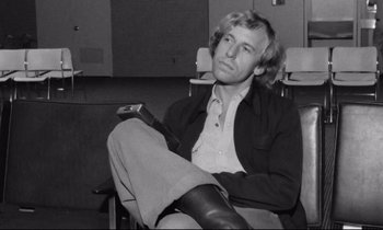 Movie still from “Alice in the Cities” (1974), directed by Wim Wenders – Black and white photograph of a man sitting in a chair; Close Up shot, Low angle