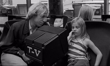 Movie still from “Alice in the Cities” (1974), directed by Wim Wenders – A man and a little girl sitting on a bus; Medium shot, Over the shoulder angle