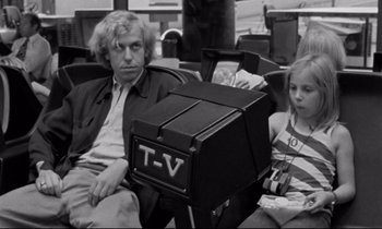 Movie still from “Alice in the Cities” (1974), directed by Wim Wenders – An older man sitting next to a little girl; Medium shot, Over the shoulder angle
