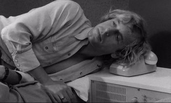 Movie still from “Alice in the Cities” (1974), directed by Wim Wenders – Black and white photograph of a man leaning on a radio; Close Up shot, High angle