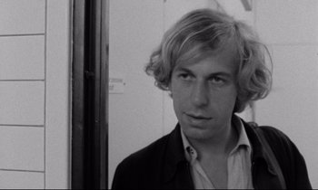 Movie still from “Alice in the Cities” (1974), directed by Wim Wenders – Black and white photograph of a man with blonde hair; Close Up shot, Low angle