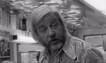 Movie still from “Alice in the Cities” (1974), directed by Wim Wenders – An older man with a beard and mustache; Close Up shot, Over the shoulder angle