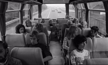 Movie still from “Alice in the Cities” (1974), directed by Wim Wenders – A black and white photo of people sitting on a bus; Wide shot, High angle