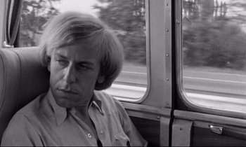 Movie still from “Alice in the Cities” (1974), directed by Wim Wenders – A black and white photo of a man sitting on a bus; Close Up shot, Over the shoulder angle