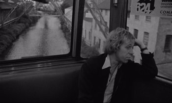 Movie still from “Alice in the Cities” (1974), directed by Wim Wenders – Black and white photograph of a man sitting on a bus; Medium shot, High angle