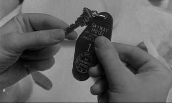 Movie still from “Alice in the Cities” (1974), directed by Wim Wenders – Two hands holding keys to a skyway hotel; Extreme Close Up shot, Overhead angle