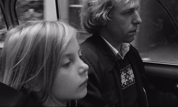 Movie still from “Alice in the Cities” (1974), directed by Wim Wenders – A man and a woman sitting next to each other on a train; Close Up shot, Low angle