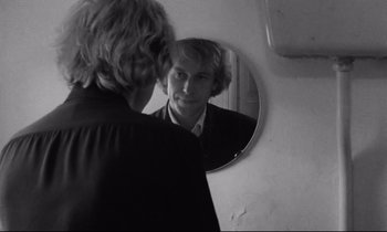 Movie still from “Alice in the Cities” (1974), directed by Wim Wenders – A man looking at himself in the mirror; Close Up shot, Over the shoulder angle