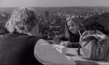 Movie still from “Alice in the Cities” (1974), directed by Wim Wenders – Two young people sitting at a table on top of a building; Medium shot, High angle
