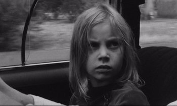 Movie still from “Alice in the Cities” (1974), directed by Wim Wenders – A little girl sitting in a car looking out the window; Close Up shot, High angle