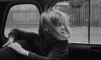 Movie still from “Alice in the Cities” (1974), directed by Wim Wenders – A little girl sitting in the back seat of a car; Medium shot, High angle