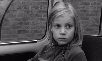 Movie still from “Alice in the Cities” (1974), directed by Wim Wenders – A little girl sitting in the back seat of a car; Close Up shot, High angle