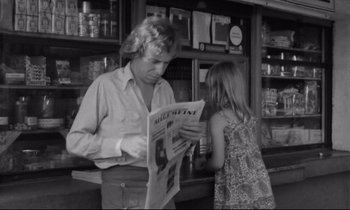 Movie still from “Alice in the Cities” (1974), directed by Wim Wenders – A man and a little girl are reading a newspaper; Medium shot, Over the shoulder angle
