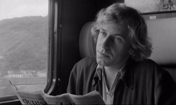 Movie still from “Alice in the Cities” (1974), directed by Wim Wenders – A man sitting on a train looking out the window; Close Up shot, Low angle