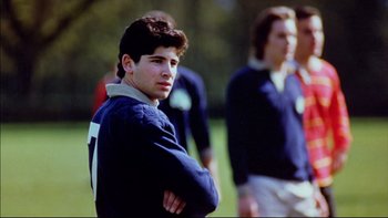 Movie still from “Alive” (1993), directed by Frank Marshall – A group of young men standing next to each other on top of a field; Close Up shot, Over the shoulder angle