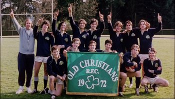 Movie still from “Alive” (1993), directed by Frank Marshall – A group of young men standing next to each other on top of a field; Medium shot, High angle